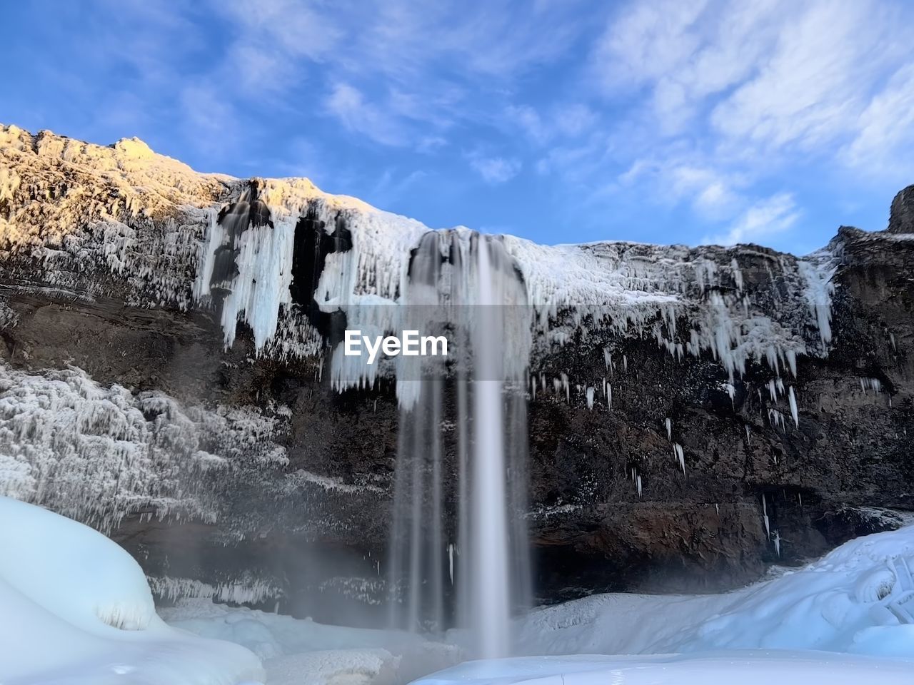 waterfall, winter, environment, cold temperature, scenics - nature, water, ice, snow, nature, beauty in nature, landscape, sky, mountain, cloud, frozen, travel destinations, travel, rock, blue, motion, glacier, no people, water feature, non-urban scene, land, outdoors, tourism, icicle, freezing, terrain, long exposure, cliff, white, day, rock formation, idyllic