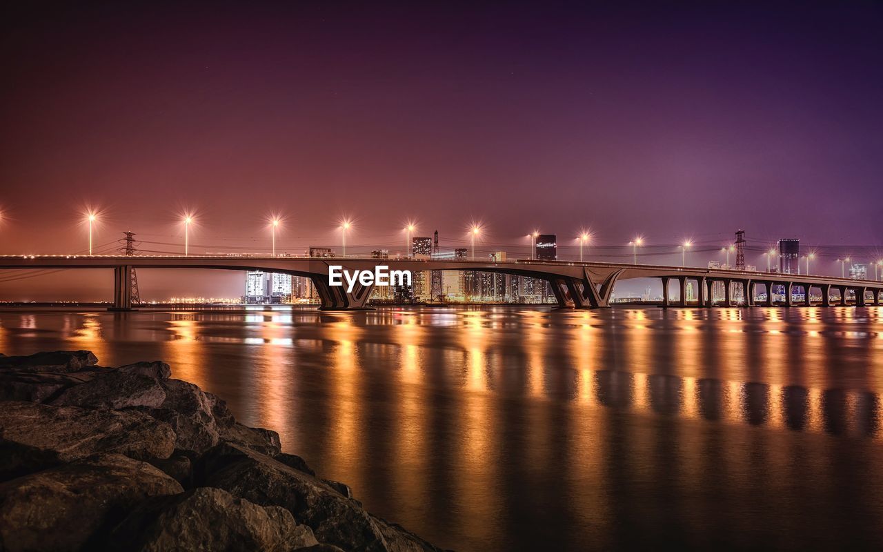 Bridge over sea against sky at night