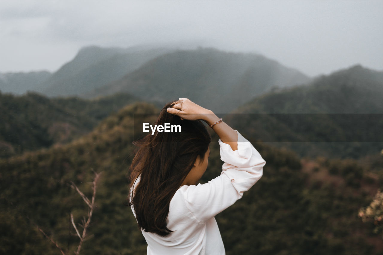 Rear view of beautiful woman standing on hill