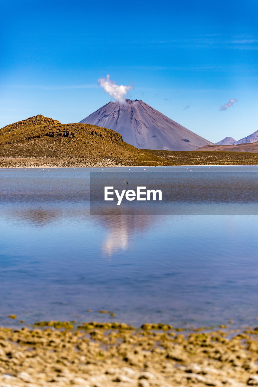 Scenic view of lake and mountains against blue sky