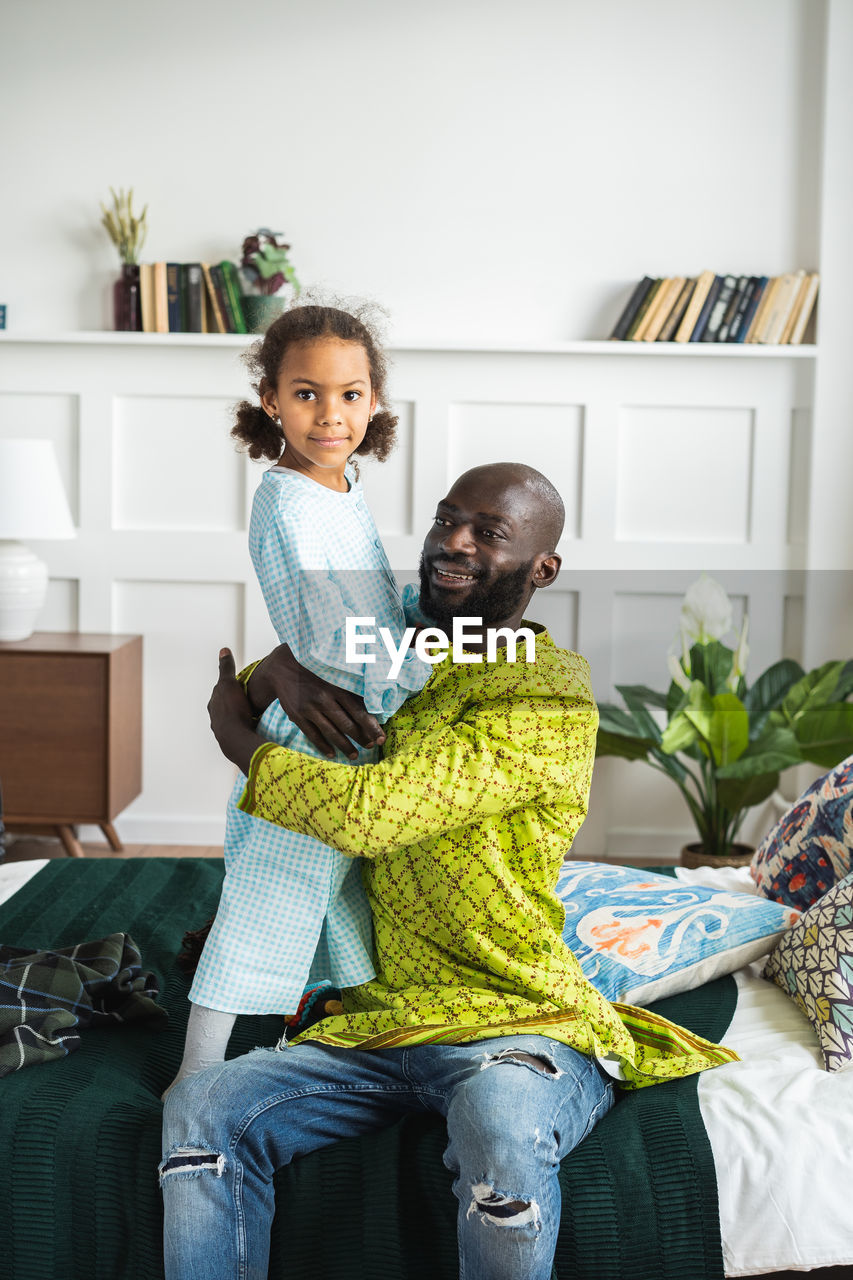 Portrait of daughter with father at home