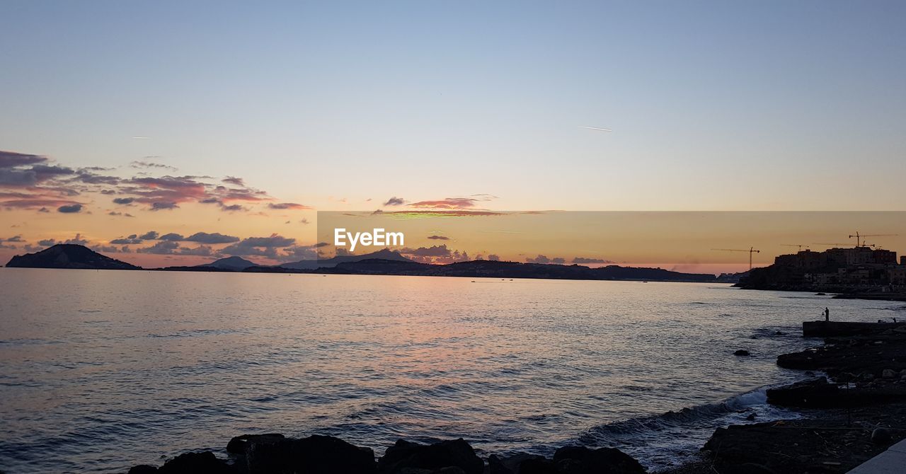 SCENIC VIEW OF SEA AGAINST ORANGE SKY