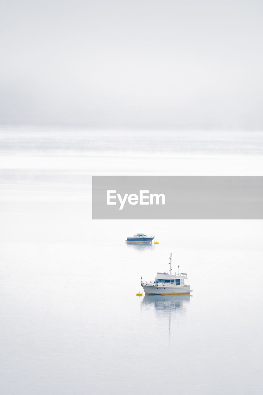 Peaceful scenery of modern boats floating on surface of calm river against cloudy sky in riano