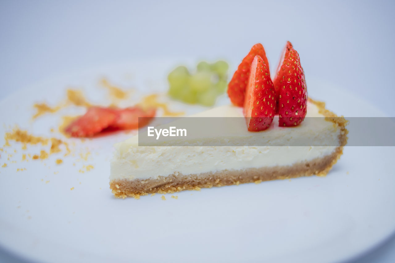 CLOSE-UP OF CAKE SLICE IN PLATE WITH CREAM