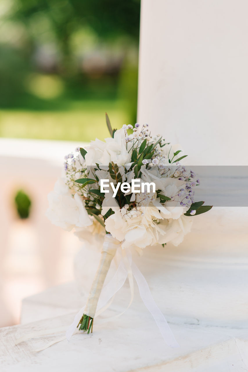 Delicate wedding bouquet with white hydrangea and greenery close-up