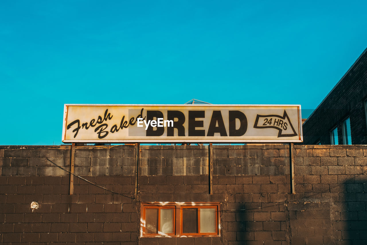 LOW ANGLE VIEW OF INFORMATION SIGN ON WALL