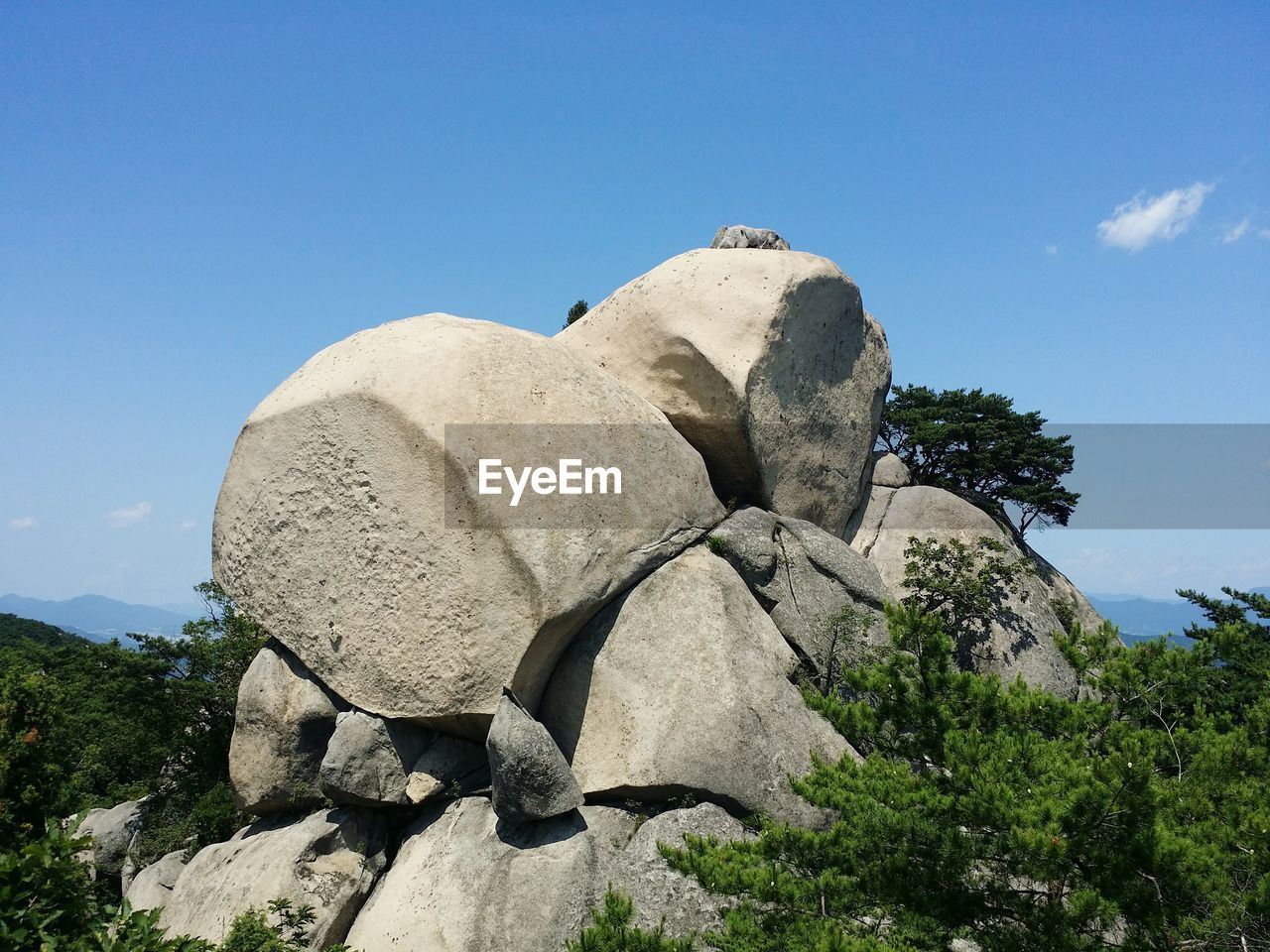 Low angle view of rocks on mountain against clear sky