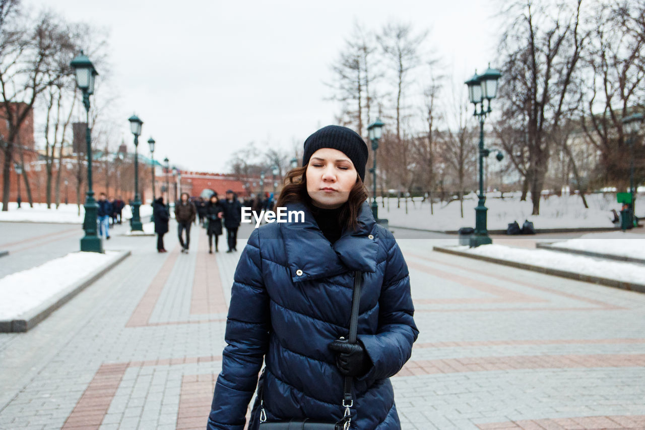 Young woman walking in city during winter