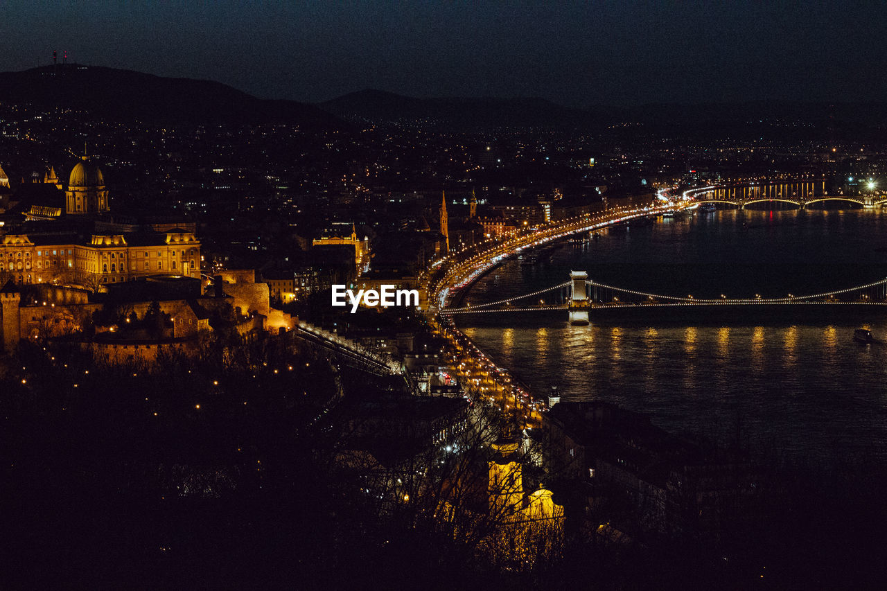 High angle view of illuminated bridge over river in city at night