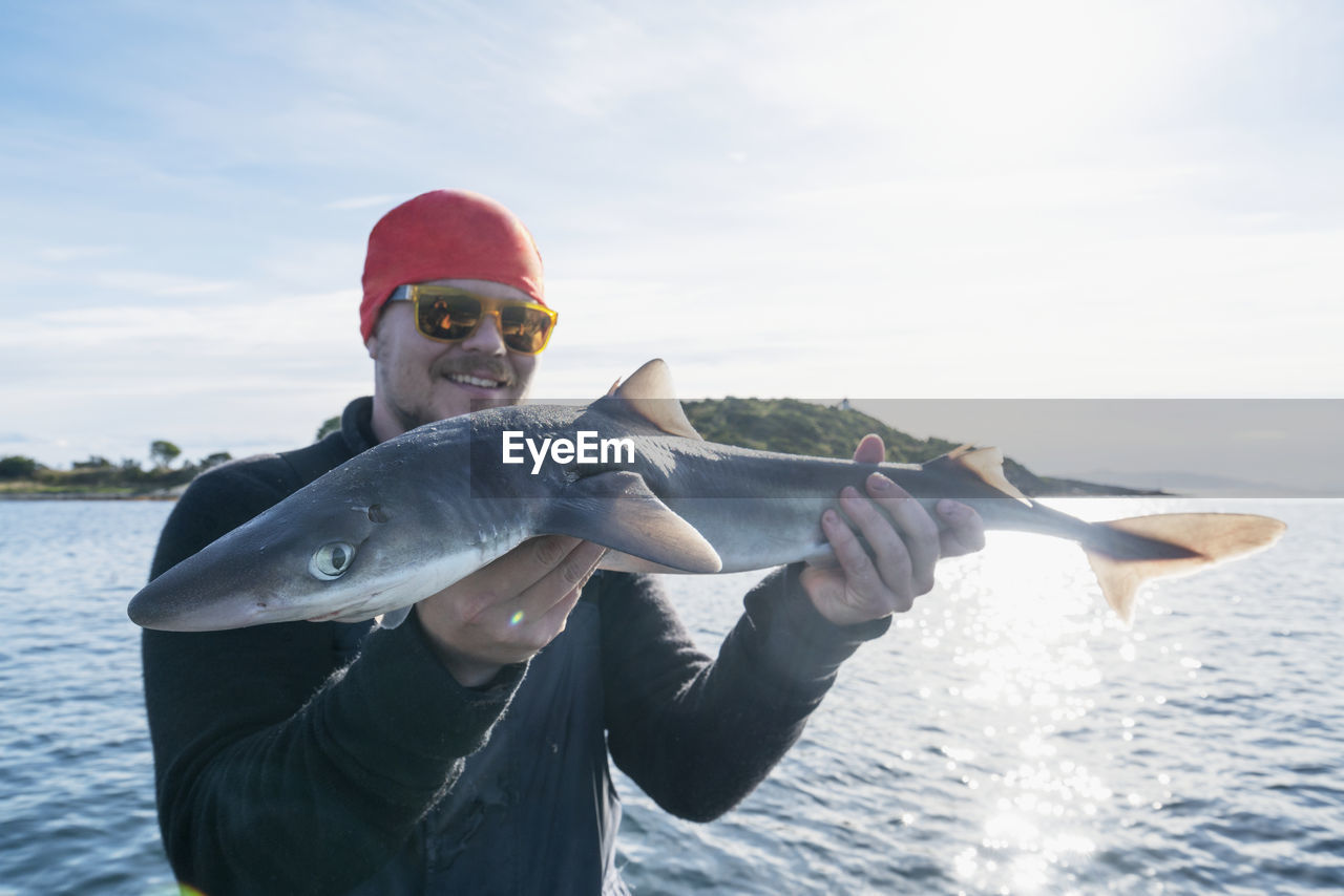 Man on boat holding fish