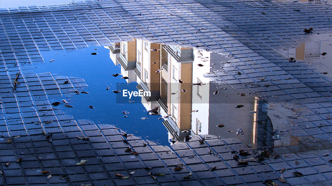HIGH ANGLE VIEW OF BUILDING IN PUDDLE