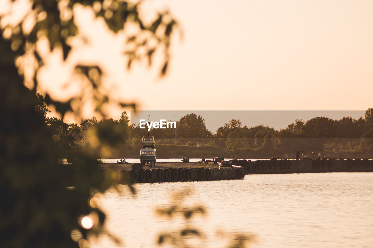 Scenic view of river against clear sky at sunset