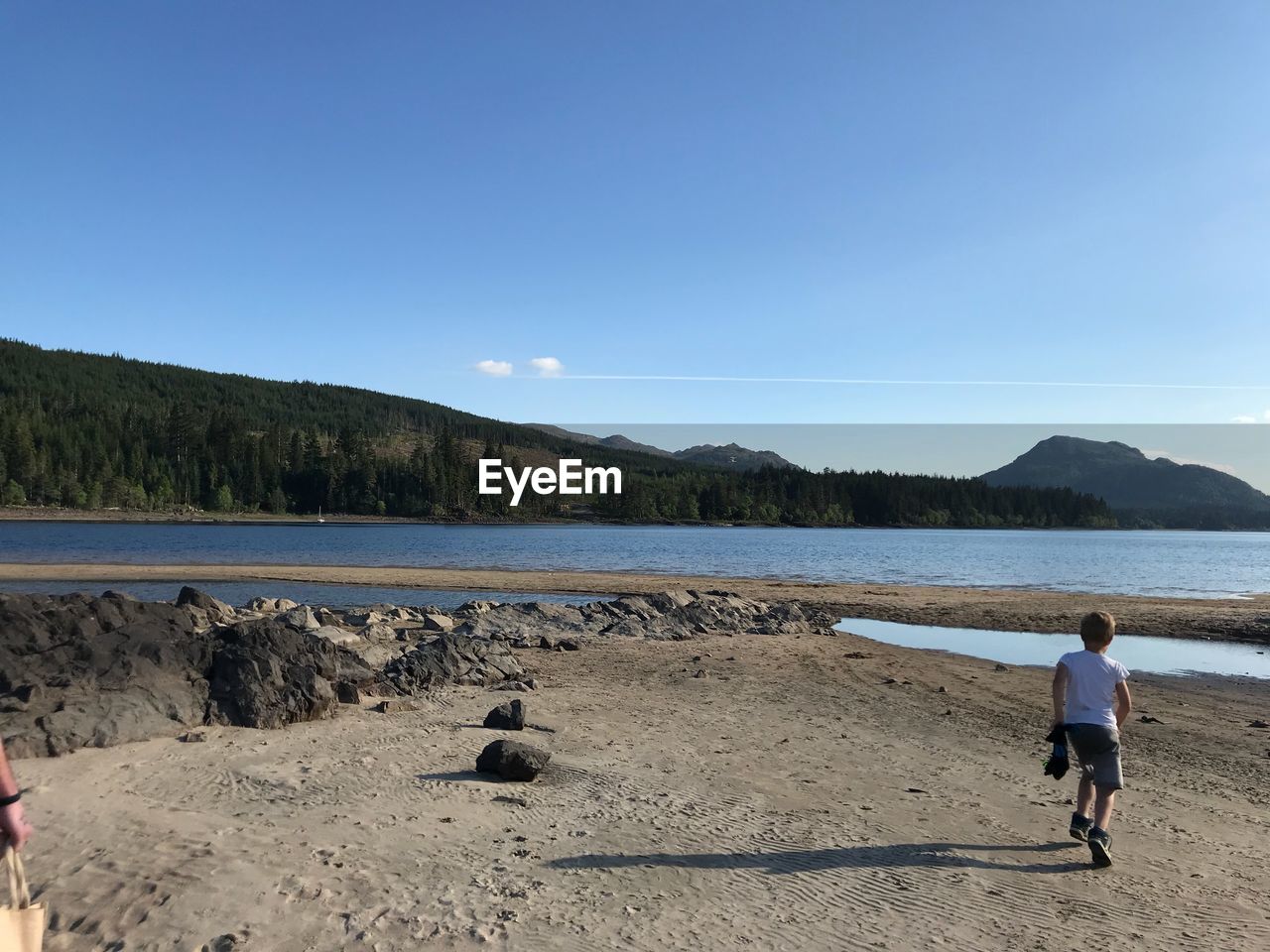 MAN ON BEACH AGAINST SKY