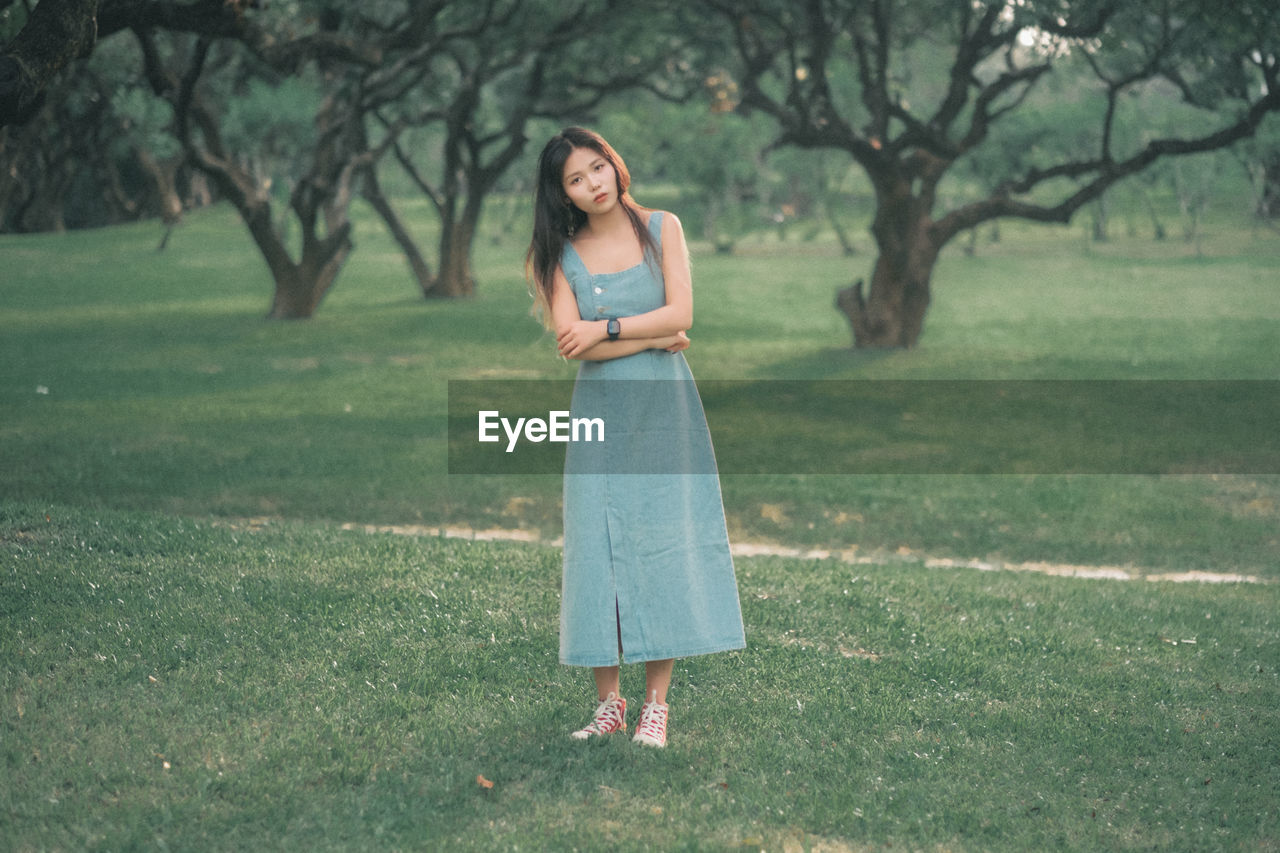 Portrait of young woman standing on field