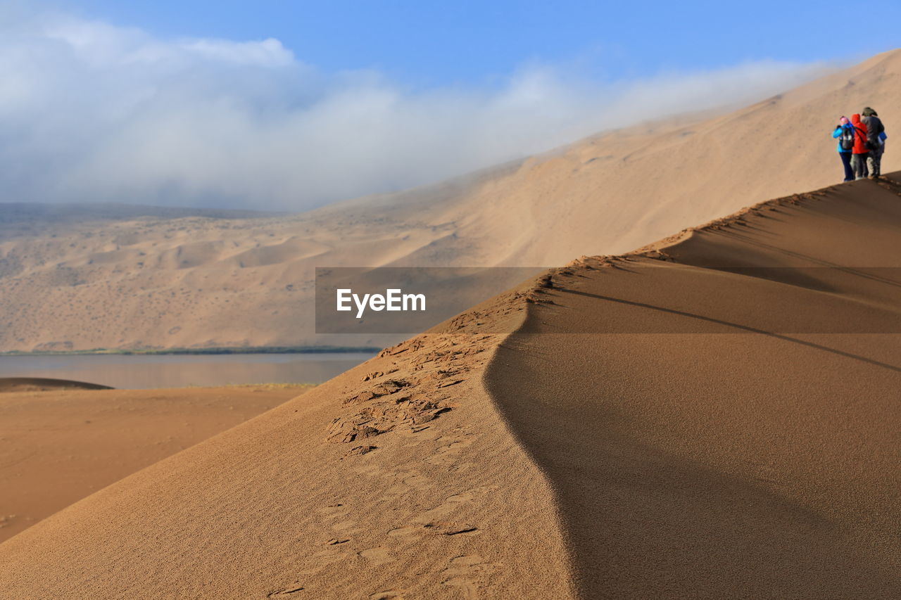 1132 tourists on a dune ridge between sumu jaran-sumu barun jaran lakes. badain jaran desert-china.