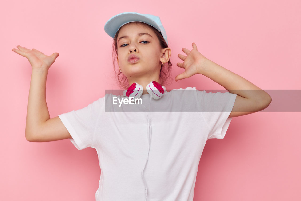 Portrait of girl dancing against pink background