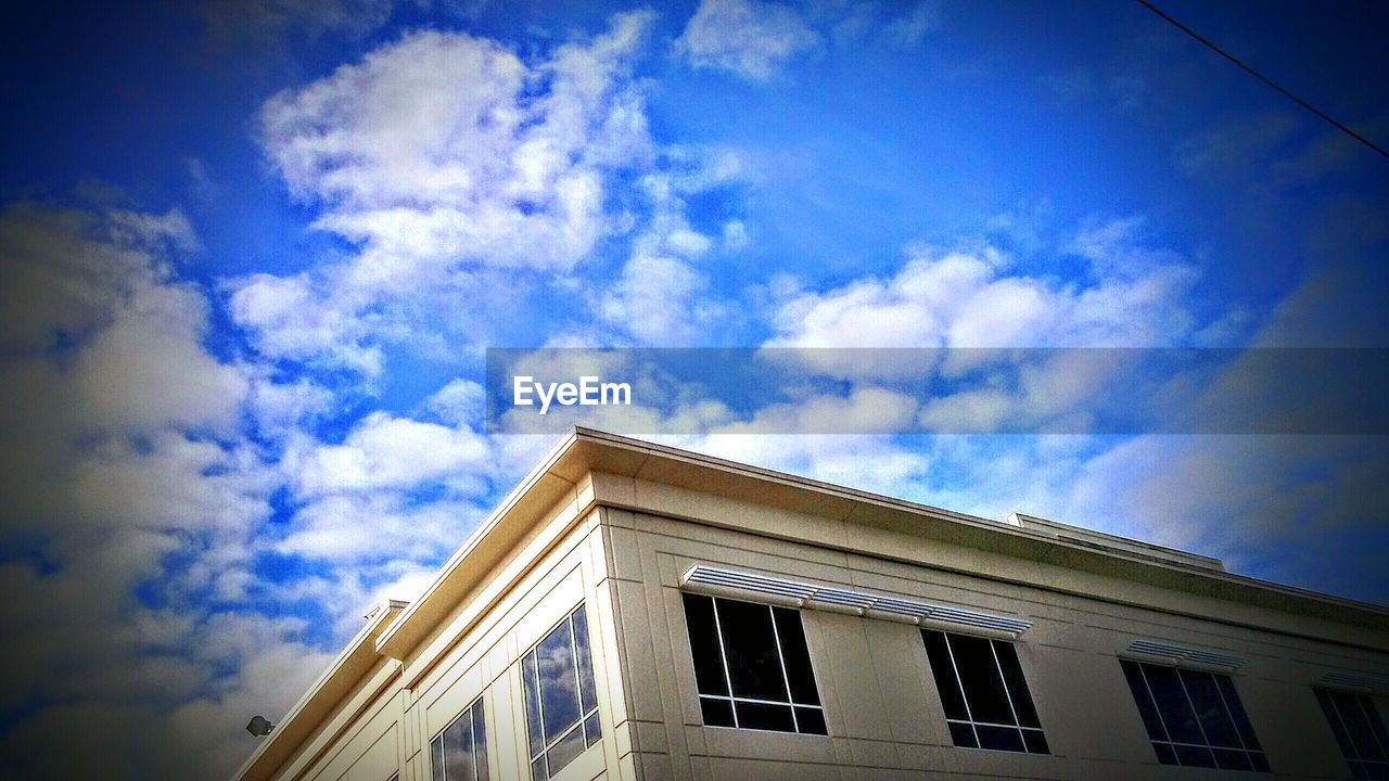 LOW ANGLE VIEW OF BUILDINGS AGAINST CLOUDY SKY