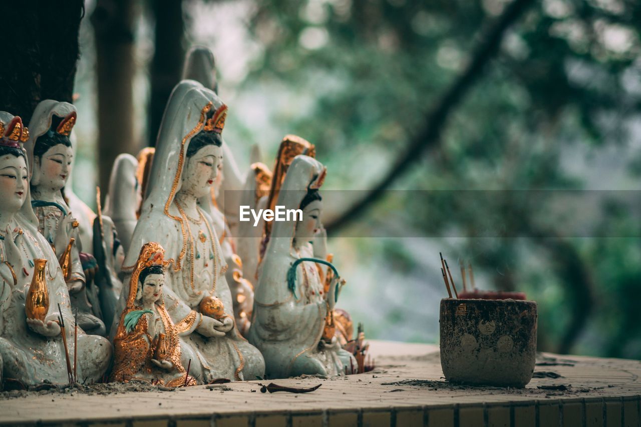 Close-up of shrine with statues against trees