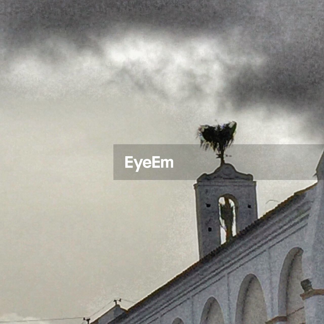 LOW ANGLE VIEW OF WEATHER FLYING AGAINST BUILDING