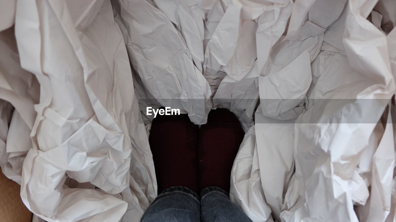 white, one person, human leg, low section, clothing, dress, indoors, shoe, human limb, adult, limb, personal perspective, lifestyles, textile, high angle view, standing, human foot, women, crumpled