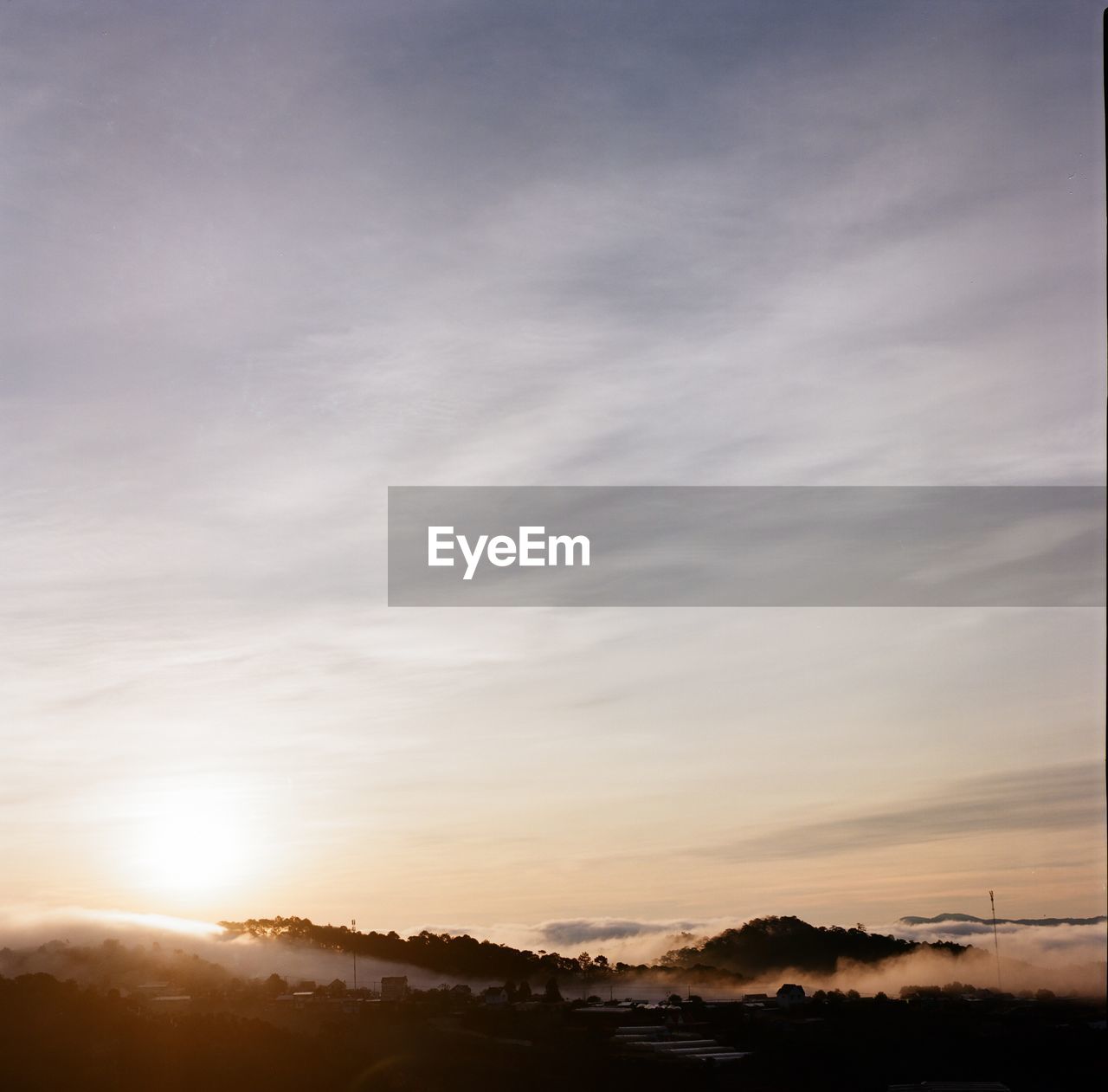 SCENIC VIEW OF SILHOUETTE LANDSCAPE AGAINST SKY DURING SUNSET AGAINST CLOUDY DAY