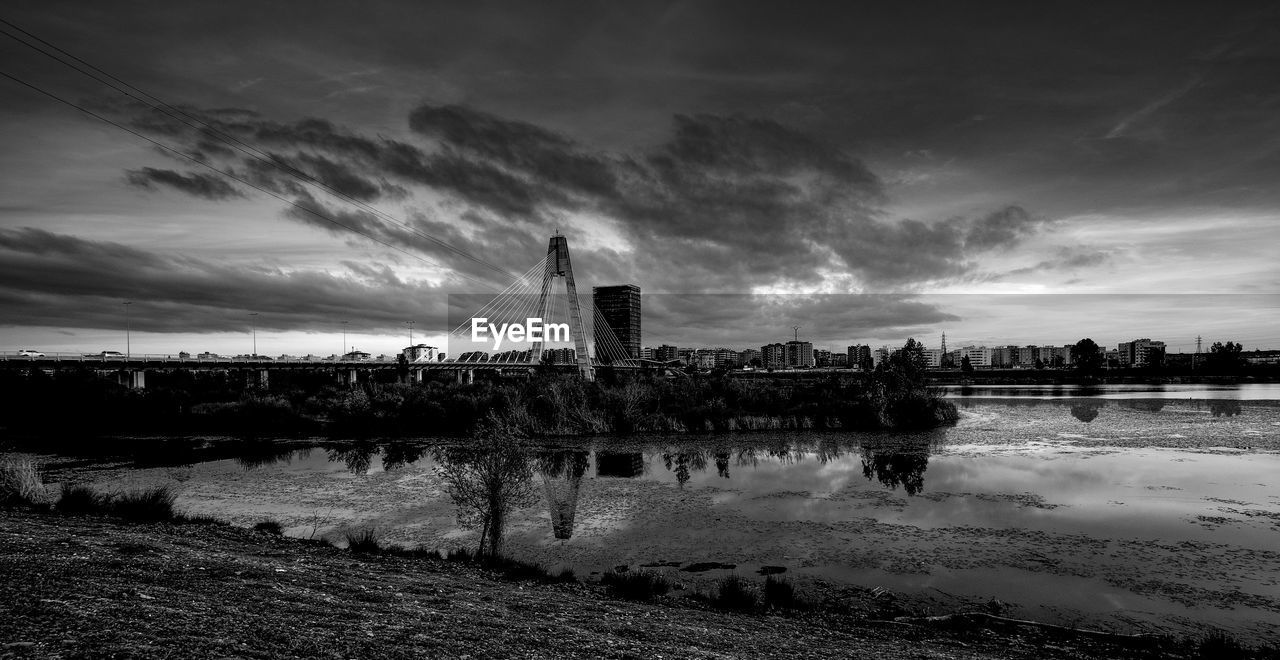 VIEW OF BRIDGE OVER RIVER AGAINST BUILDINGS