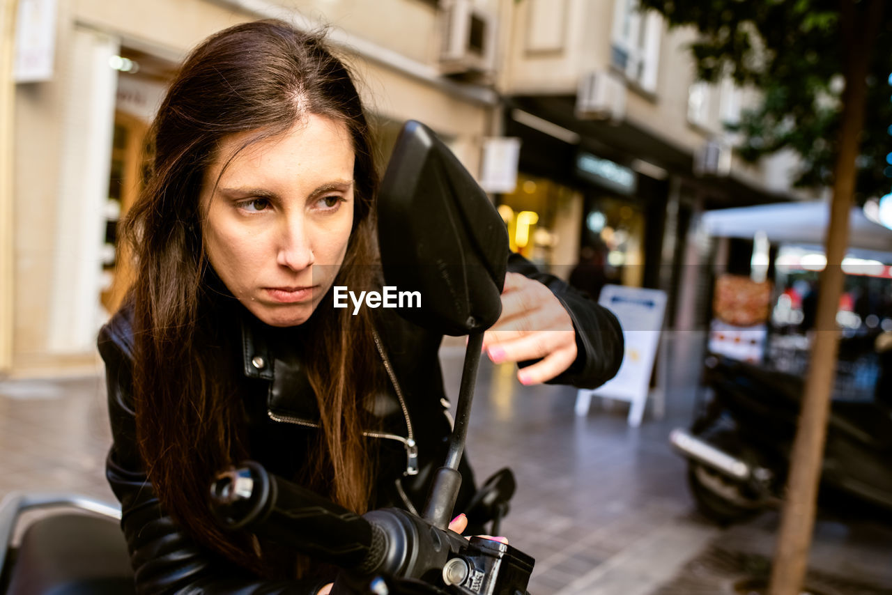 Woman looking at side-view mirror