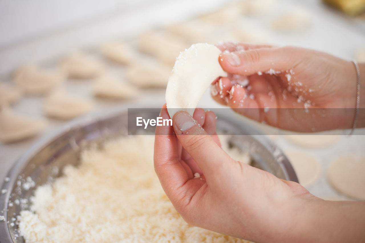 CROPPED IMAGE OF PERSON HOLDING ICE CREAM IN KITCHEN