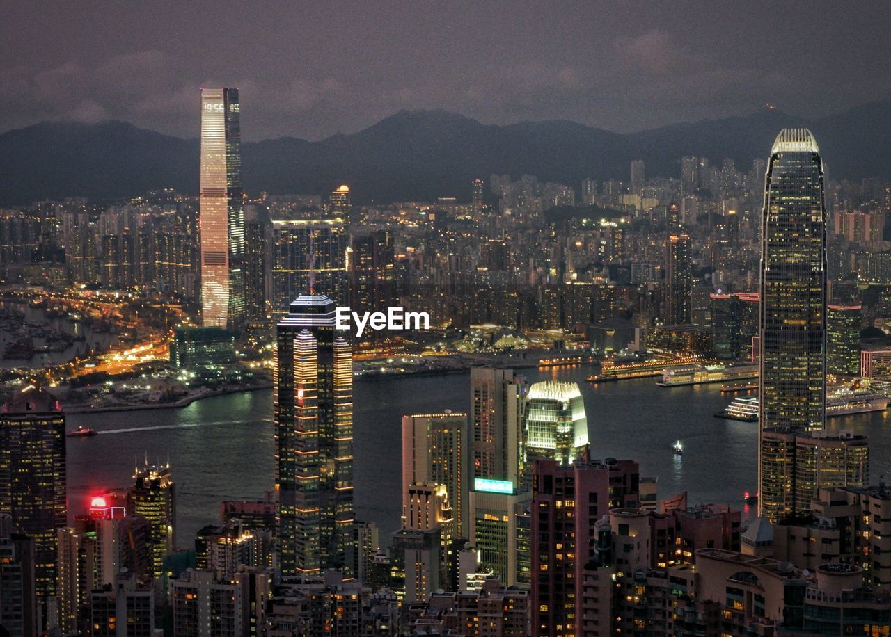 Illuminated cityscape against sky at night