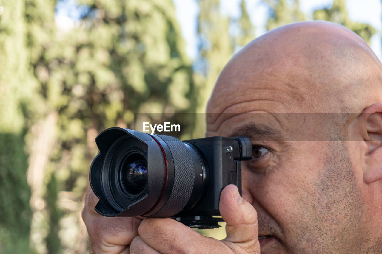 Close-up, man takes pictures with a dslr camera, outdoors.