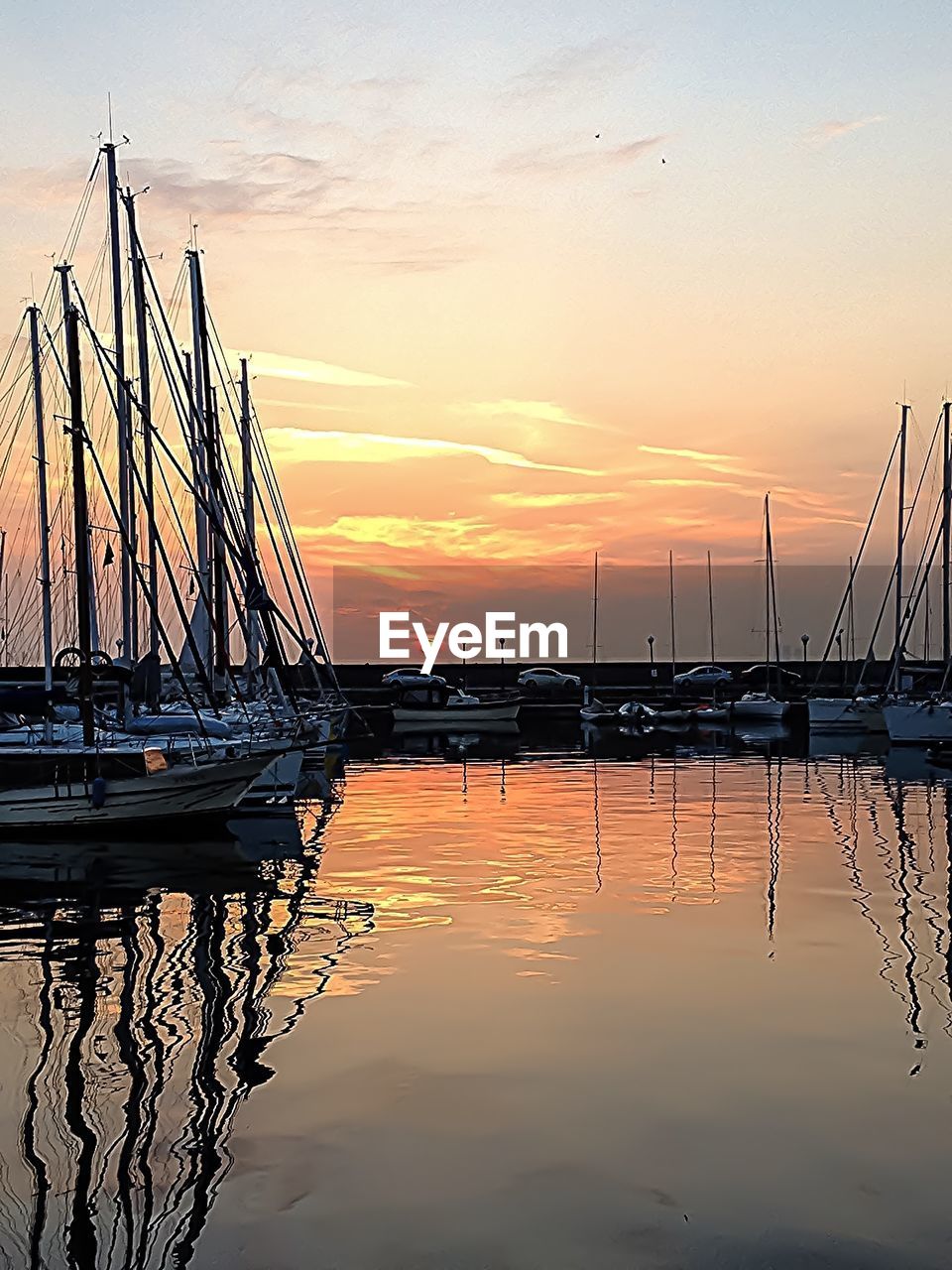 SAILBOATS MOORED AT SUNSET