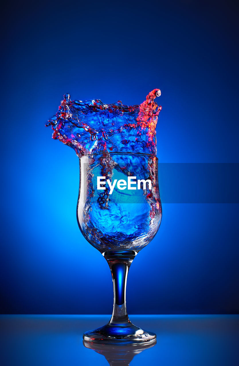 Wineglass on table against blue background