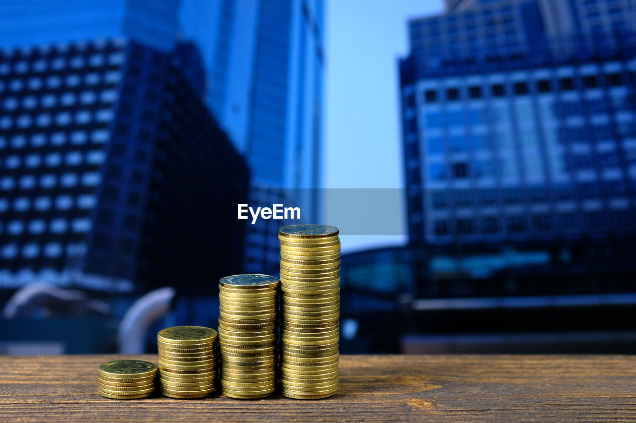 STACK OF COINS ON TABLE AGAINST BLUE SKY