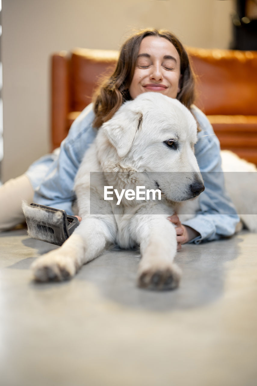 Portrait of woman with dog relaxing at home