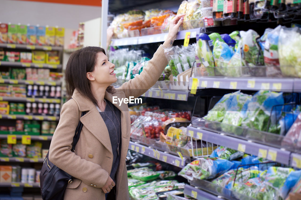 Smiling woman looking at shelf in store