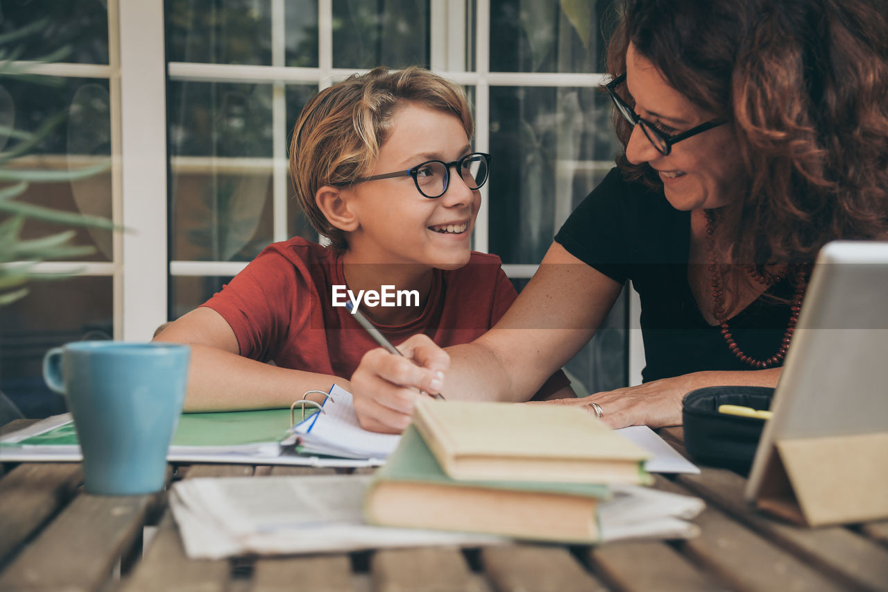 Mature woman helping son with studies at home