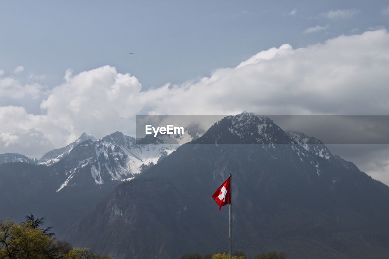 Switzerland flag against rocky mountains
