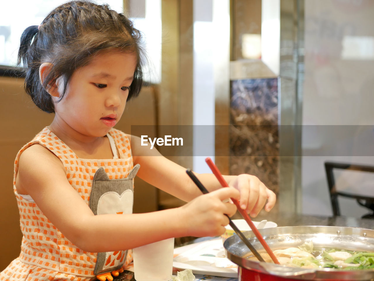 Cute girl eating food at home