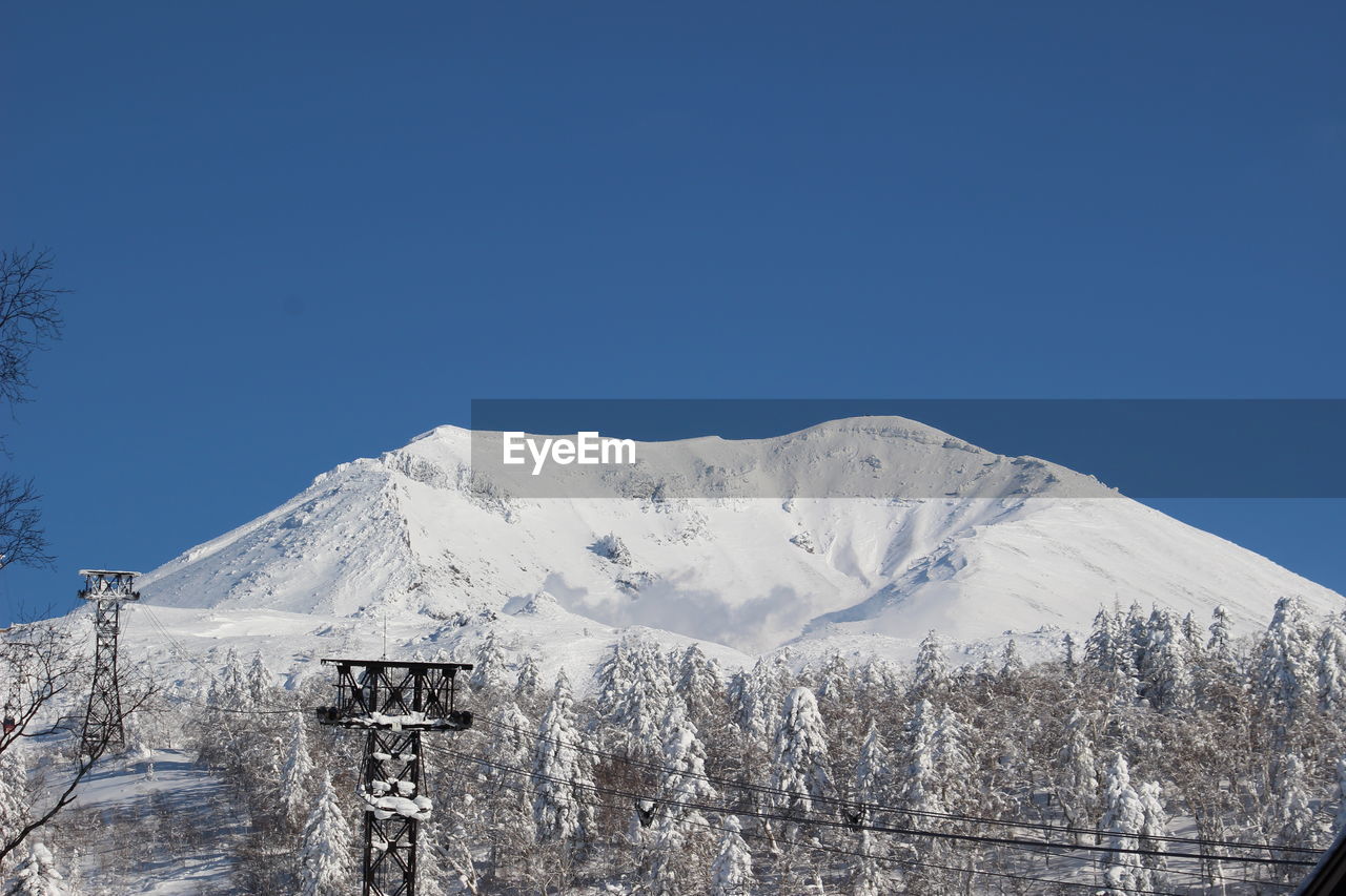 Scenic view of snowcapped mountains against clear blue sky