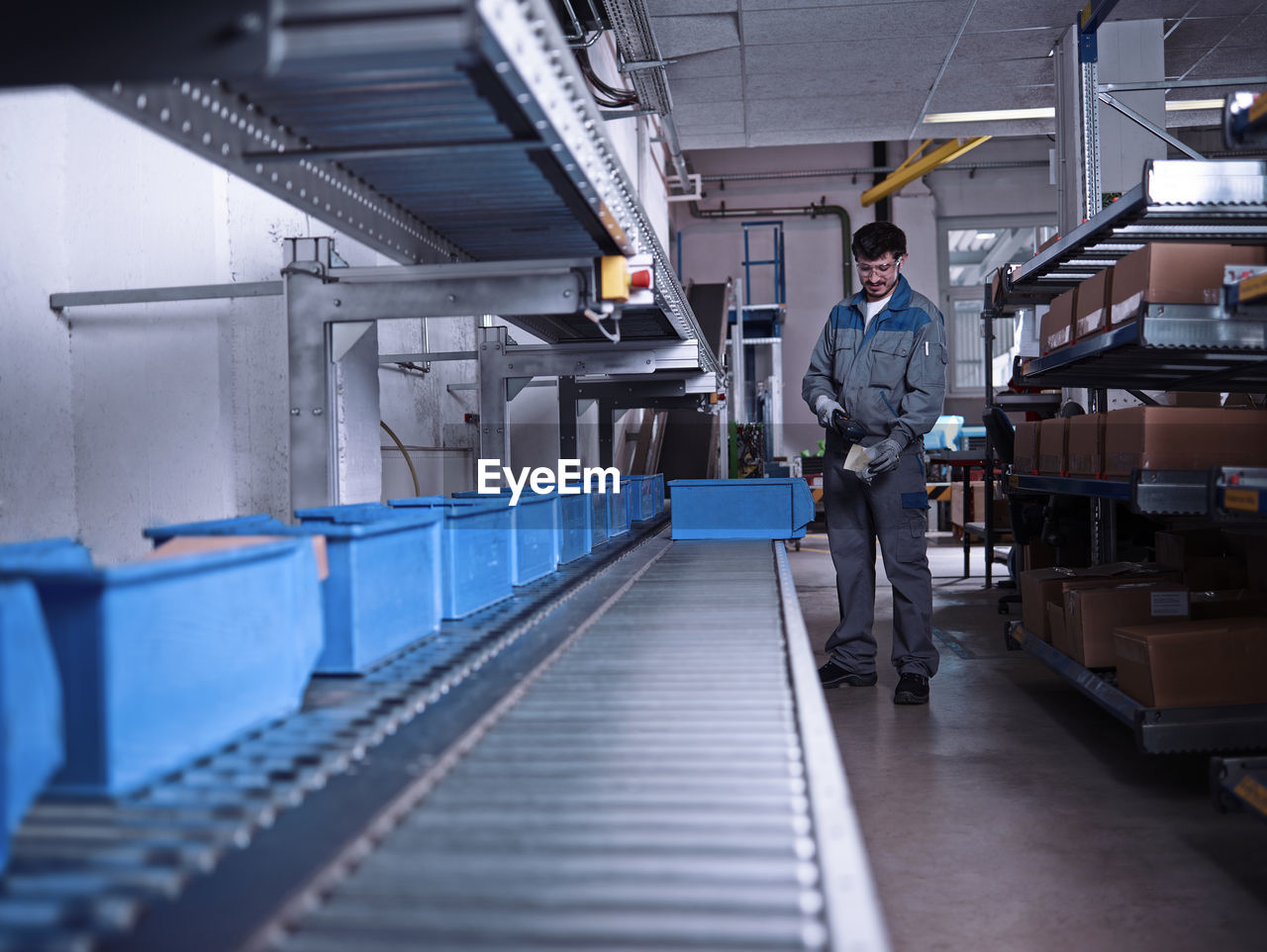 Worker scanning merchandise at conveyor belt