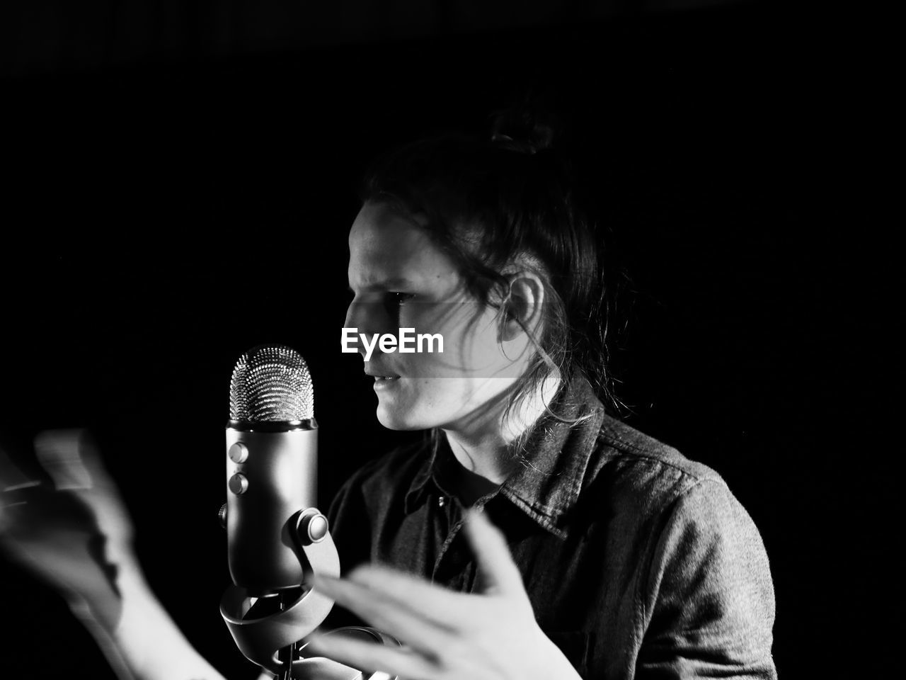 Close-up of singer singing in darkroom