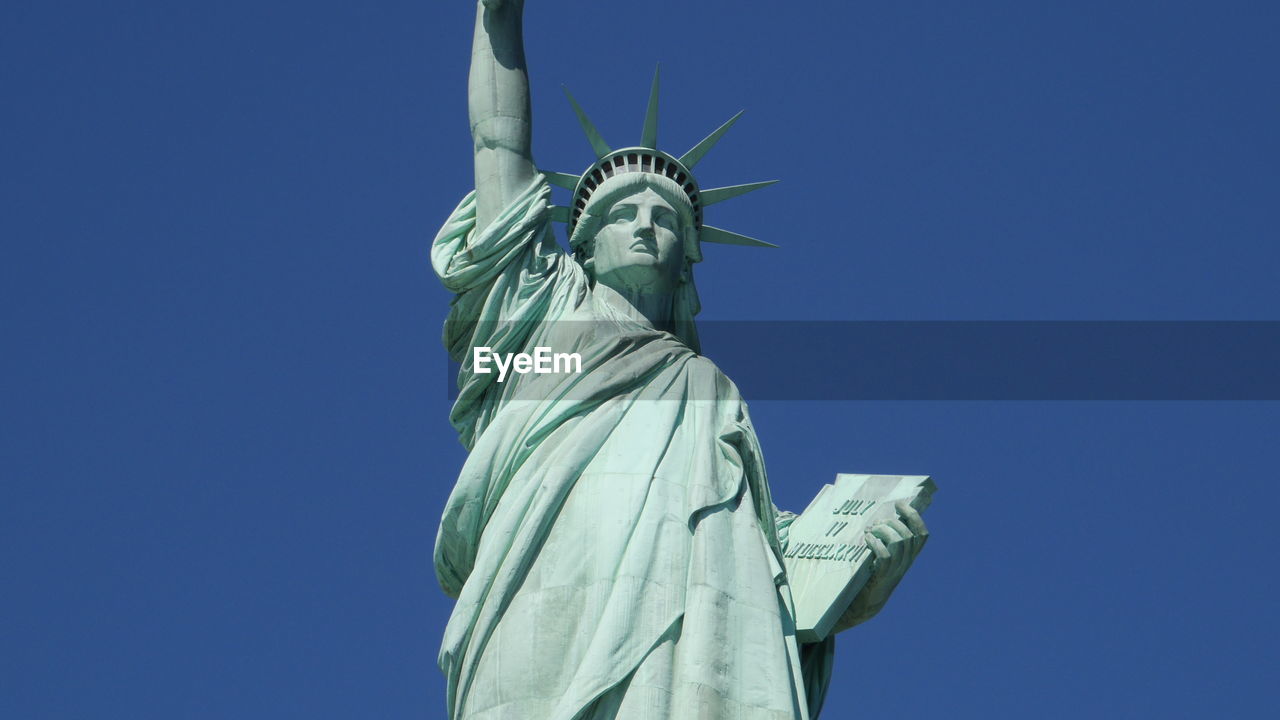 Low angle view of statue against blue sky
