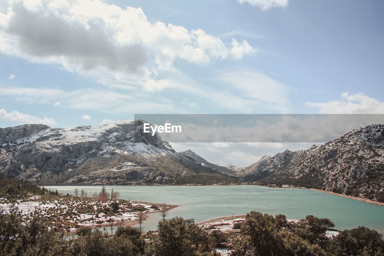 Scenic view of lake and mountains against sky