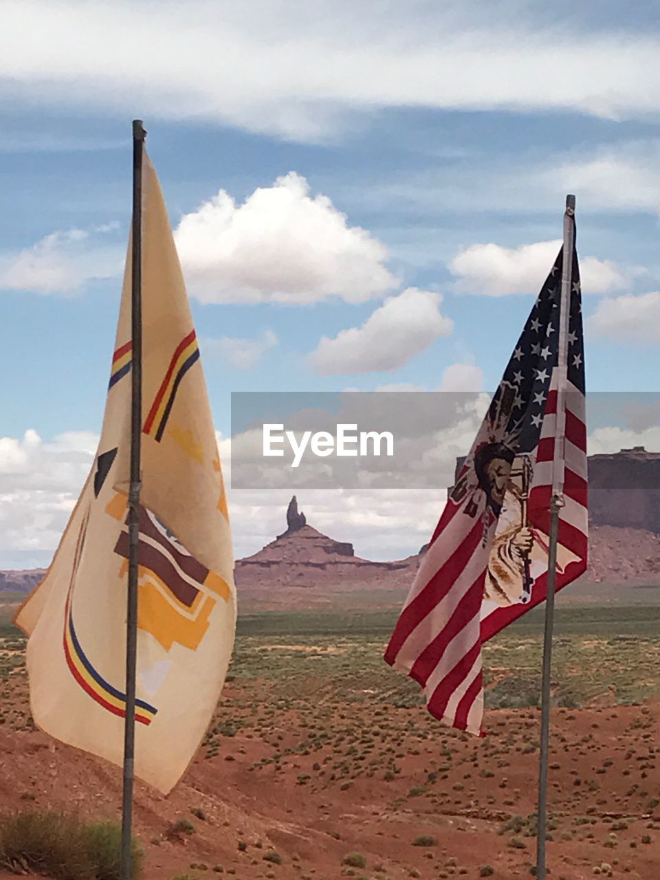 Flags on landscape against sky