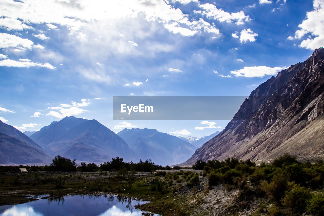 SCENIC VIEW OF LAKE AMIDST MOUNTAINS AGAINST SKY