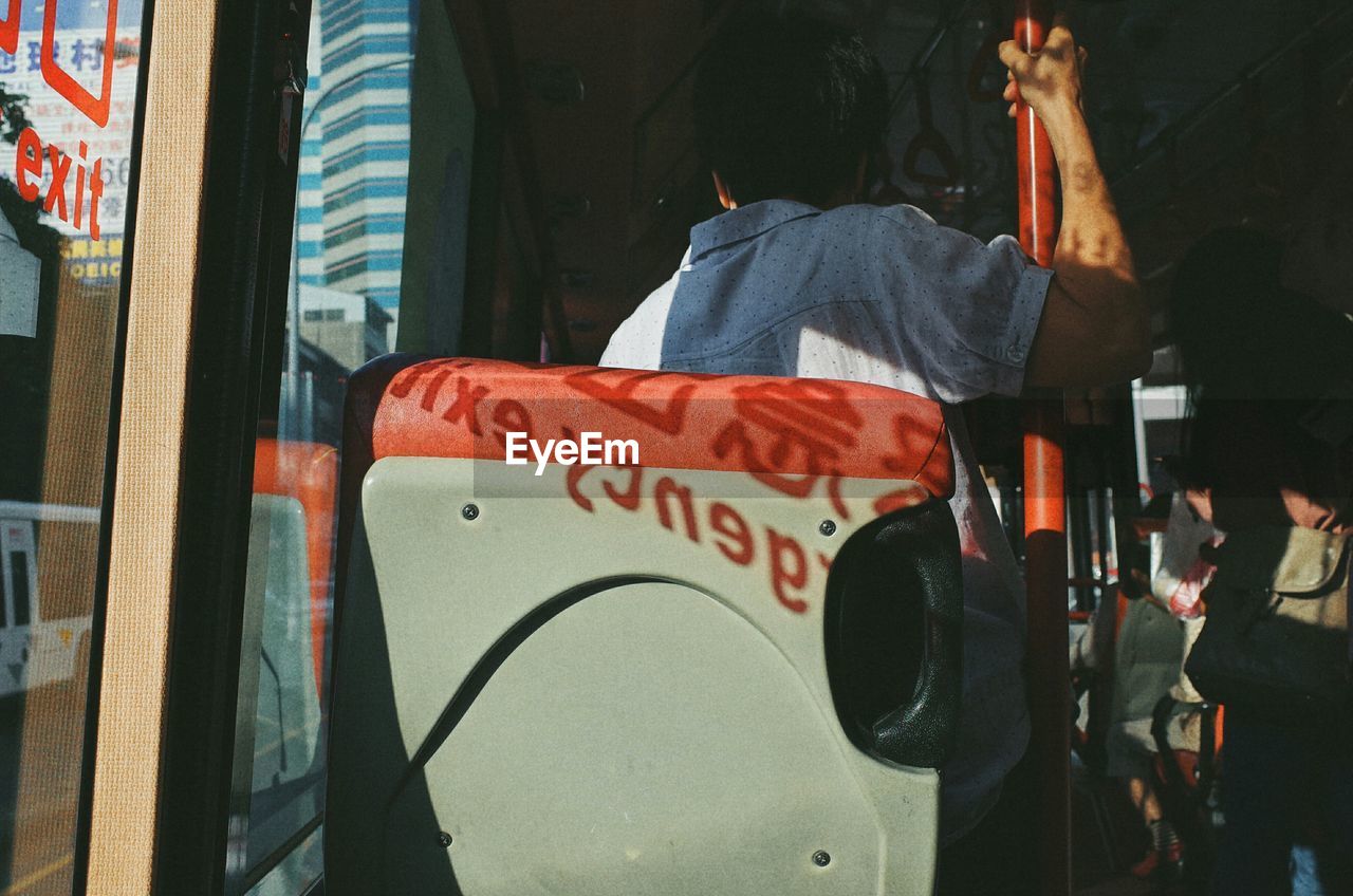 Rear view of man traveling in bus