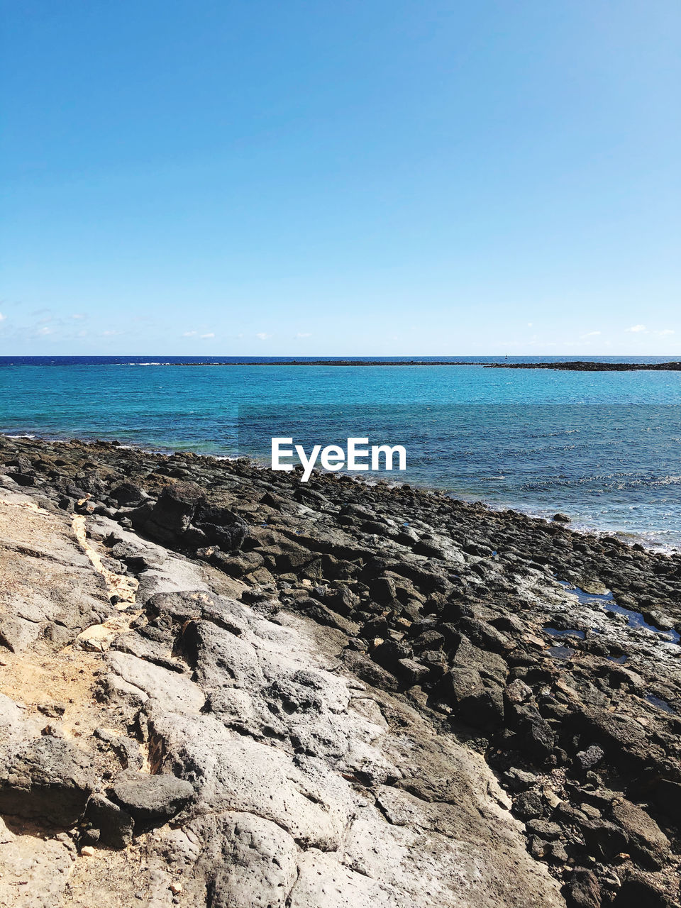 Scenic view of sea against clear blue sky