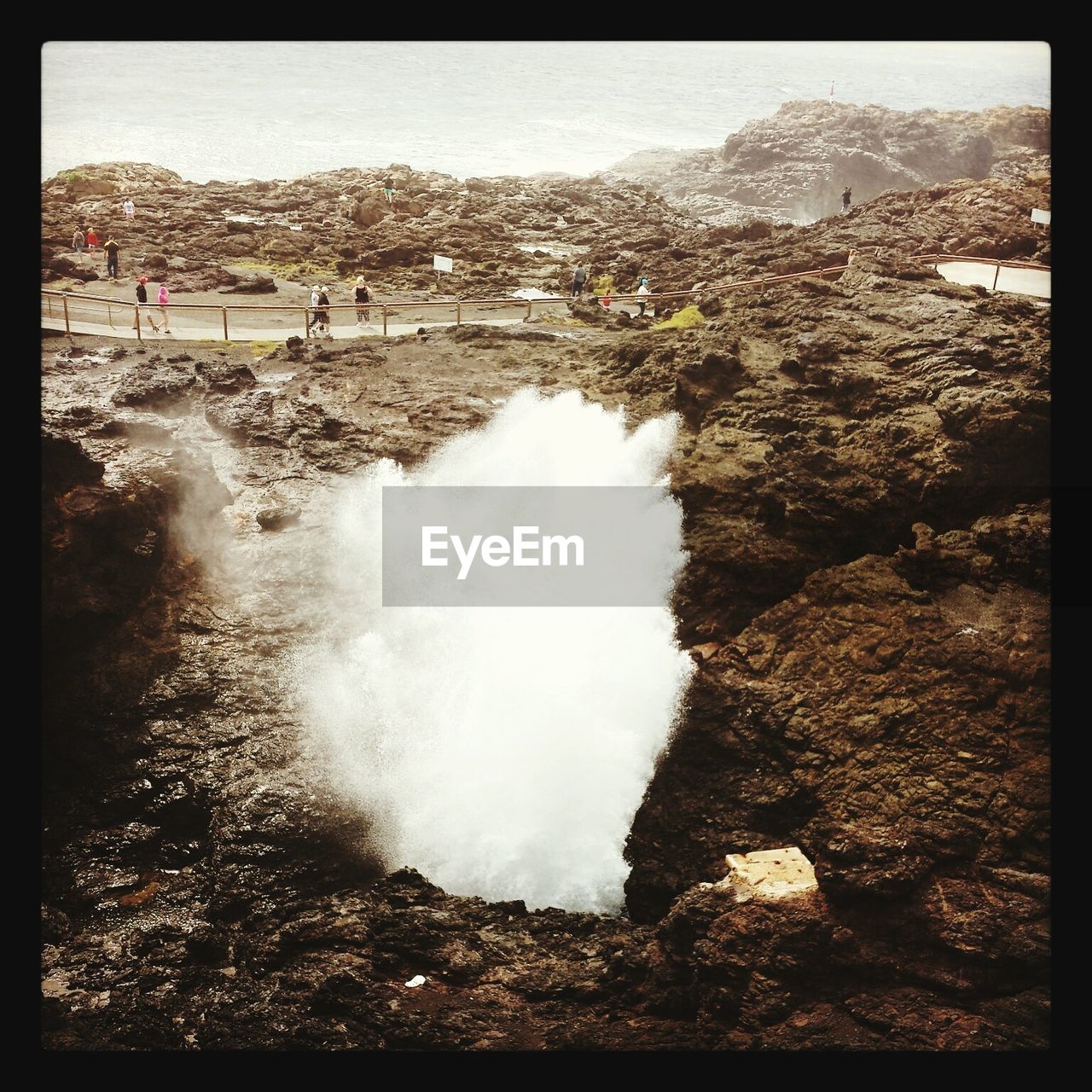 High angle view of splashing water amidst rock formation at kiama blowhole