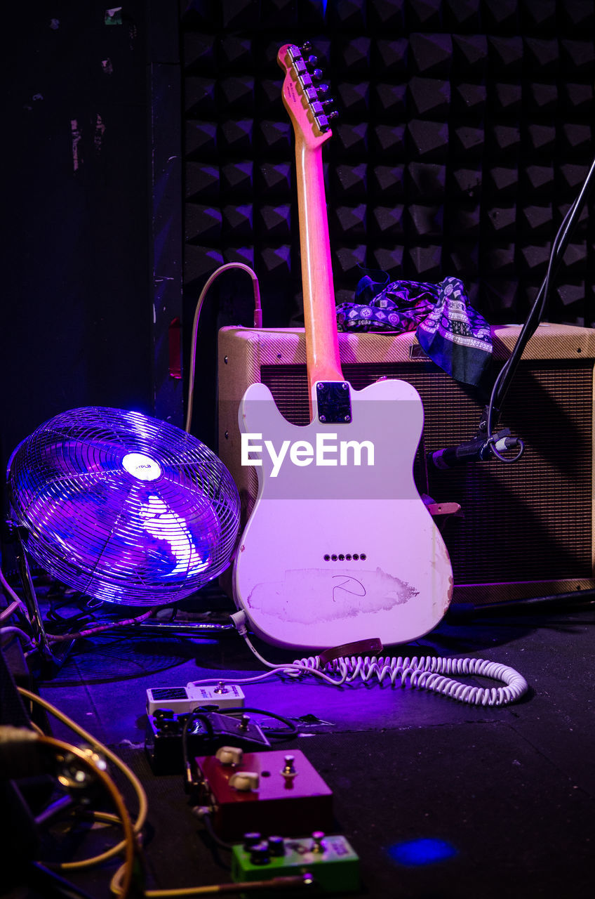 CLOSE-UP OF GUITAR ON ILLUMINATED TABLE