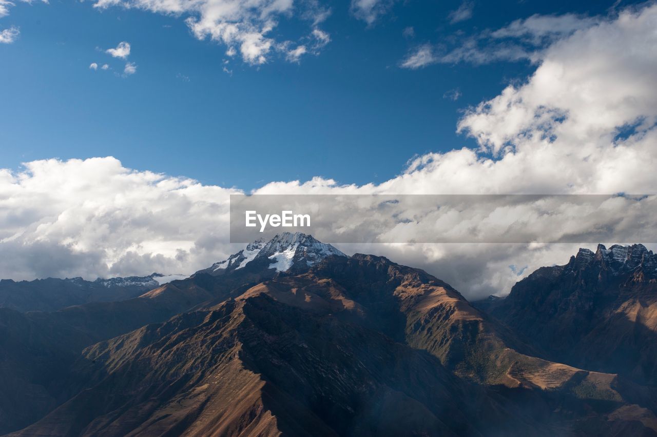 Scenic view of snowcapped mountains against cloudy sky